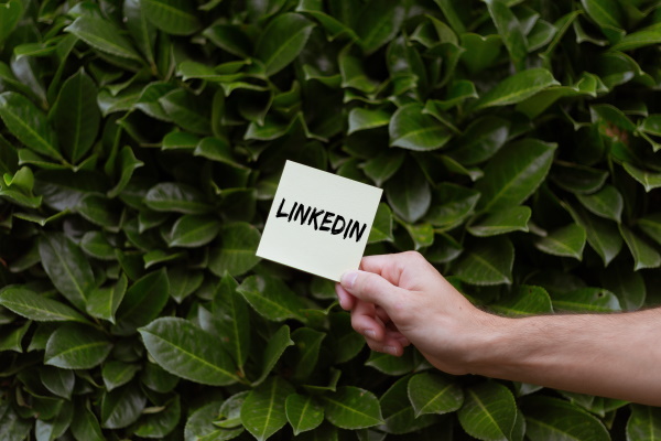 person-holding-a-card-with-linkedin-text