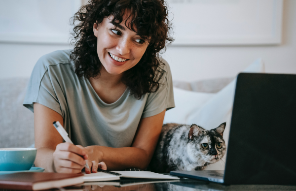 woman-in-t-shirt-looking-at-laptop-with-a-cat